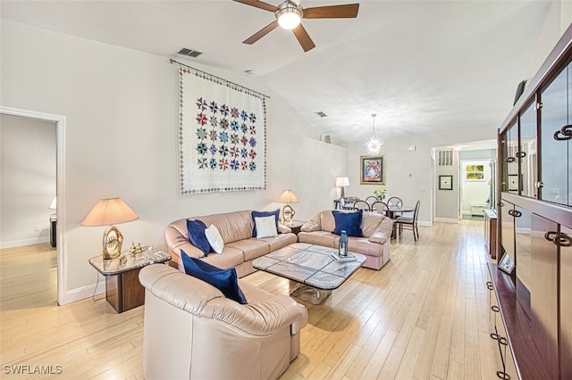 living room with visible vents, baseboards, light wood-type flooring, vaulted ceiling, and a ceiling fan