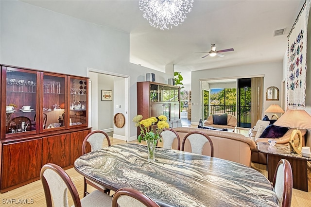 dining space with ceiling fan with notable chandelier, visible vents, light wood finished floors, and baseboards