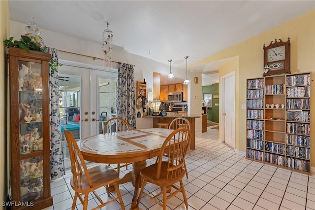 dining space featuring light tile patterned flooring and french doors