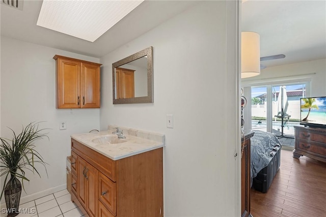 bathroom featuring visible vents, baseboards, and vanity