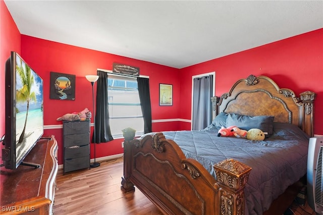 bedroom with wood finished floors and baseboards