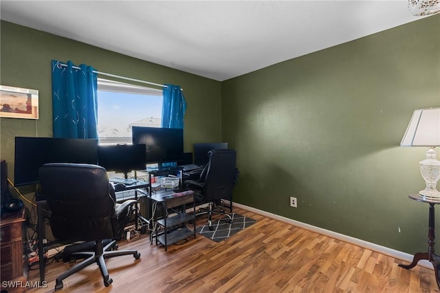 home office with baseboards and wood finished floors