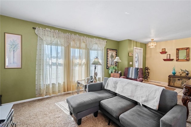 carpeted living area with an inviting chandelier and baseboards