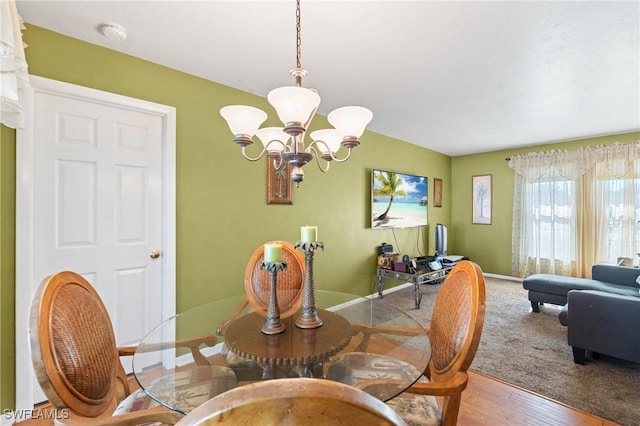 dining space featuring an inviting chandelier, wood finished floors, and baseboards