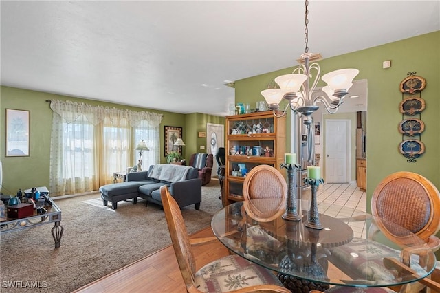 dining space featuring light carpet and a notable chandelier