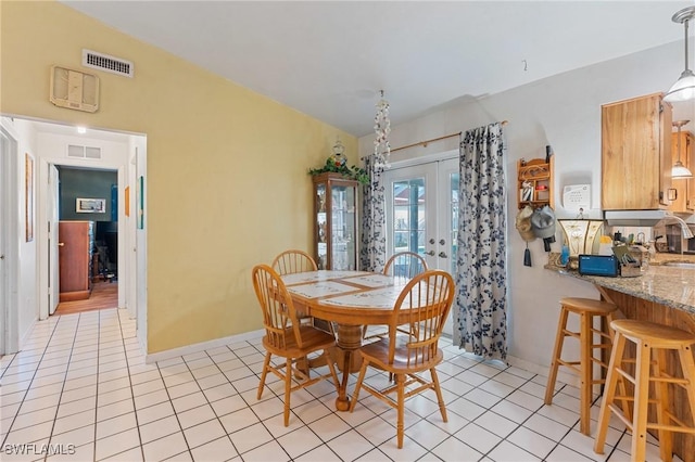 dining room with light tile patterned floors, french doors, and visible vents