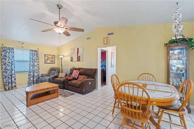 dining space with light tile patterned floors, visible vents, a ceiling fan, and vaulted ceiling