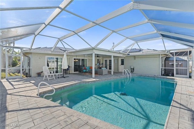 outdoor pool featuring glass enclosure, a patio, a ceiling fan, and an outdoor living space