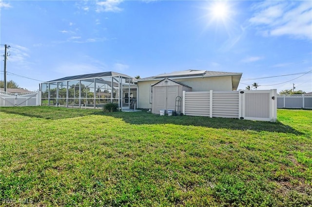 back of house with a storage unit, a yard, a fenced backyard, and an outdoor structure