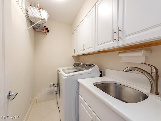 laundry area with baseboards, cabinet space, a sink, tile patterned floors, and washer and clothes dryer