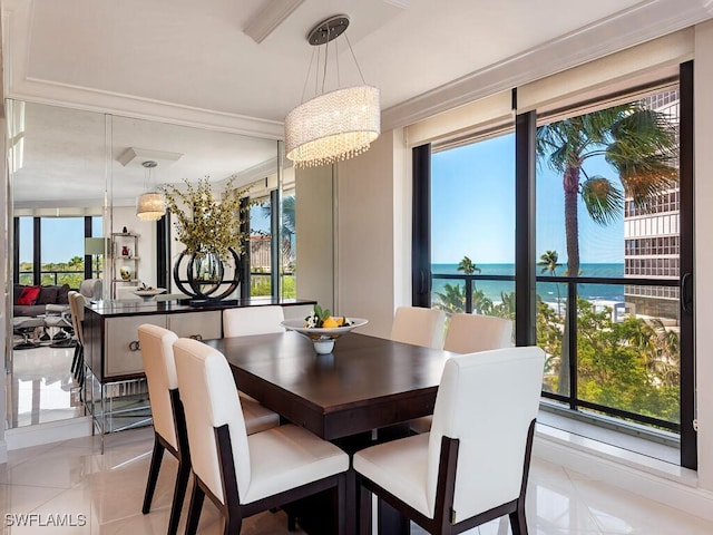 dining space featuring a water view, ornamental molding, and an inviting chandelier