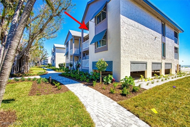 view of side of property featuring a yard and stucco siding