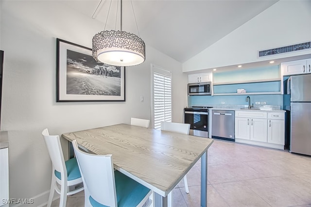 kitchen featuring visible vents, a sink, vaulted ceiling, white cabinets, and appliances with stainless steel finishes