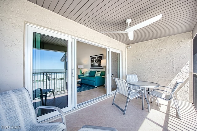 balcony with outdoor dining area and ceiling fan