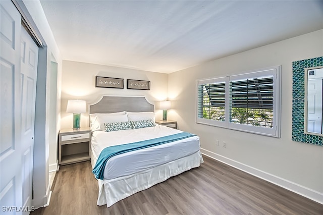 bedroom featuring wood finished floors and baseboards