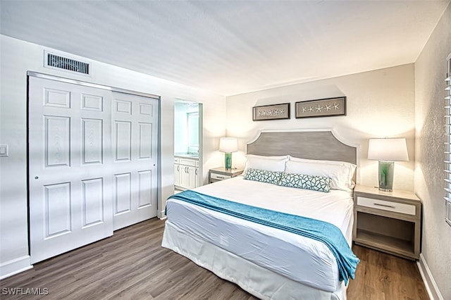 bedroom featuring wood finished floors, visible vents, a closet, and baseboards