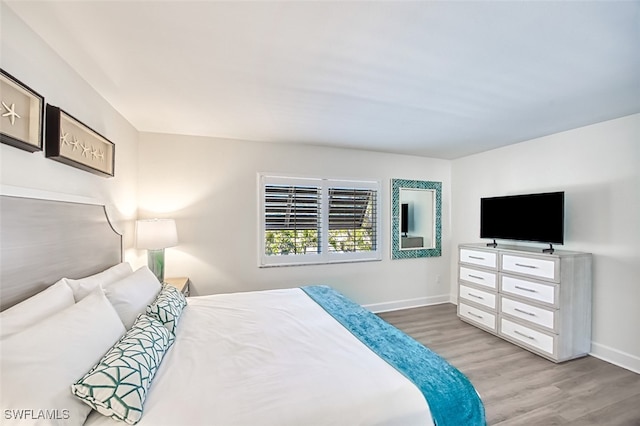 bedroom with baseboards and wood finished floors