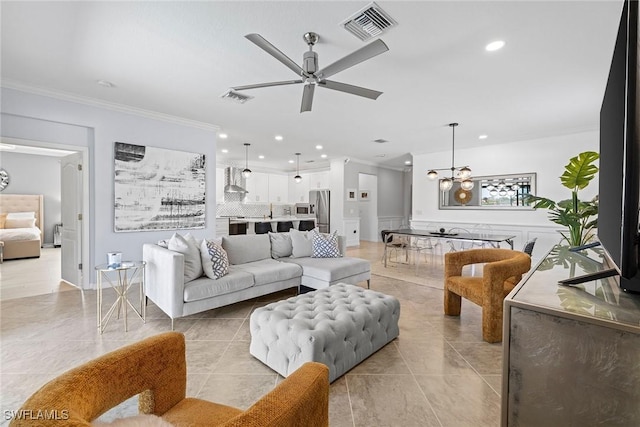 living room featuring recessed lighting, visible vents, crown molding, and ceiling fan with notable chandelier