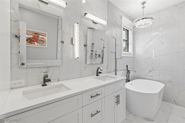 full bathroom with a sink, a freestanding tub, marble finish floor, and double vanity