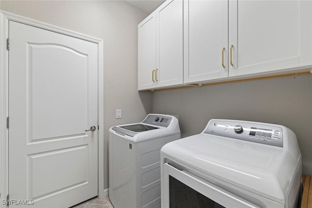 laundry room with washing machine and clothes dryer and cabinet space