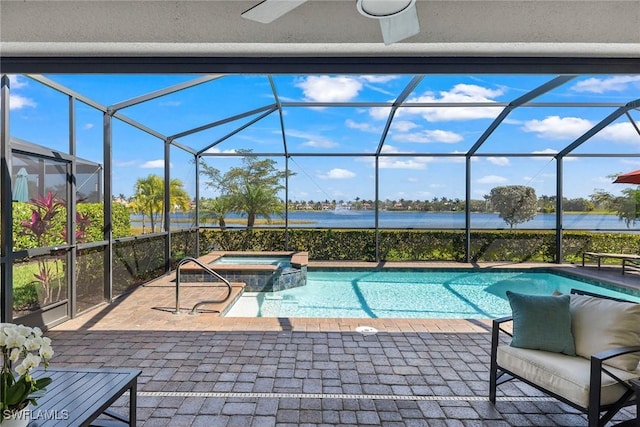 view of pool with a water view, a pool with connected hot tub, a lanai, and a patio area