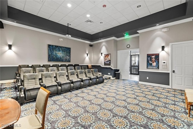 home theater featuring visible vents, a raised ceiling, ornamental molding, and carpet flooring