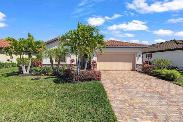 mediterranean / spanish-style home featuring a tile roof, a front yard, stucco siding, decorative driveway, and an attached garage