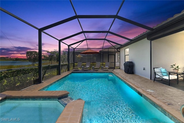 view of pool with a patio area, a grill, a pool with connected hot tub, and a lanai