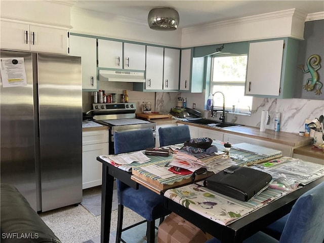 kitchen featuring crown molding, under cabinet range hood, stainless steel appliances, light speckled floor, and a sink