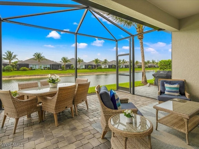 view of patio / terrace featuring grilling area, a water view, a residential view, glass enclosure, and outdoor dining area