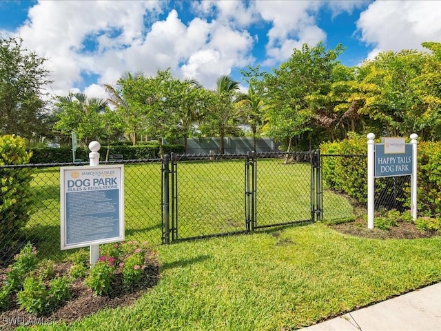 view of gate with a lawn and fence