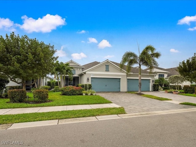 view of front facade with decorative driveway, a front yard, and an attached garage