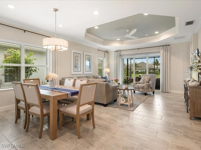 dining space with baseboards, visible vents, a tray ceiling, recessed lighting, and ornamental molding