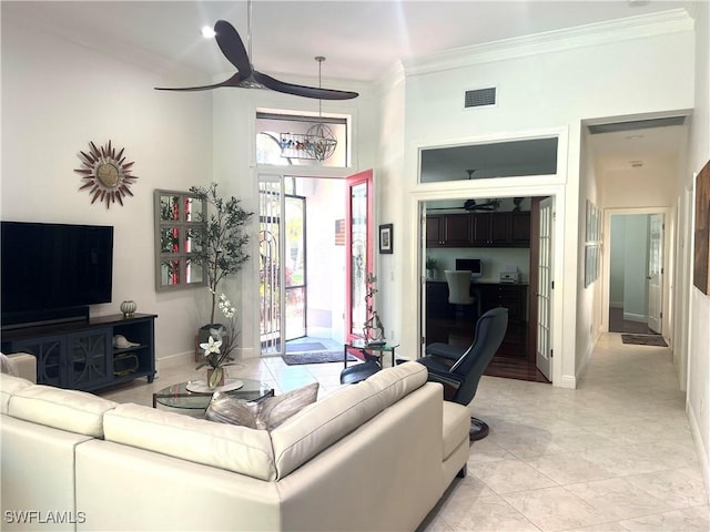 living area with baseboards, visible vents, built in study area, ceiling fan, and crown molding