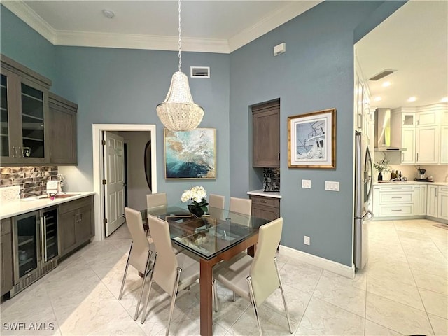 dining space with crown molding, beverage cooler, baseboards, and visible vents