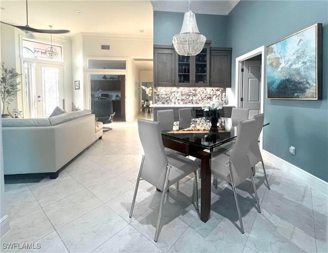 dining space with an inviting chandelier, baseboards, marble finish floor, and ornamental molding