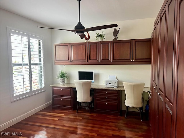 office featuring baseboards, dark wood-type flooring, ceiling fan, and built in study area