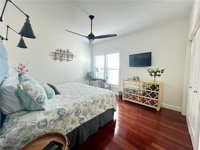 bedroom featuring a closet, ceiling fan, baseboards, and wood finished floors