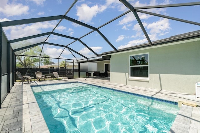 view of pool featuring glass enclosure, a patio, and a fenced in pool