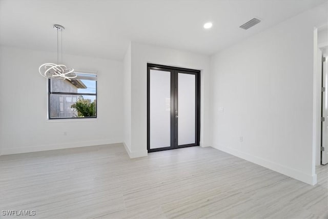 5306 Lee St, Lehigh Acres, FL 33971 - spare room with french doors, baseboards, a notable chandelier, and light wood finished floors