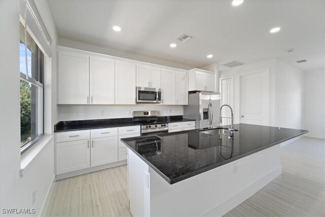 5306 Lee St, Lehigh Acres, FL 33971 - kitchen featuring visible vents, a kitchen island with sink, a sink, stainless steel appliances, and white cabinets