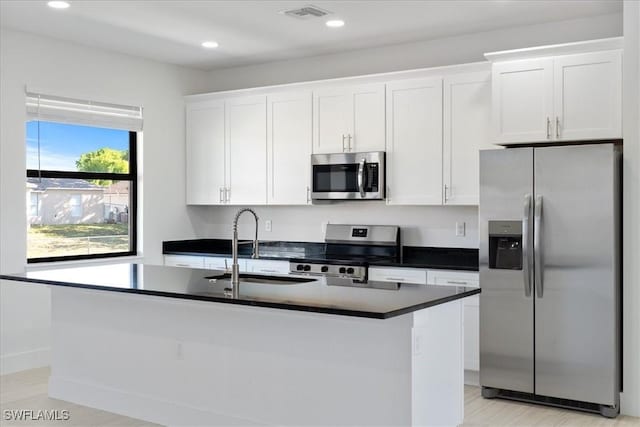5306 Lee St, Lehigh Acres, FL 33971 - kitchen with visible vents, a center island with sink, white cabinets, stainless steel appliances, and a sink
