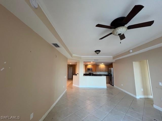 kitchen featuring open floor plan, a tray ceiling, dark countertops, visible vents, and a ceiling fan