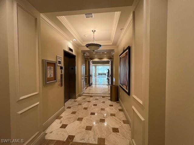 hallway with a tray ceiling, elevator, baseboards, visible vents, and ornamental molding