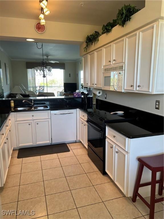 kitchen with white appliances, white cabinets, light tile patterned floors, and a sink