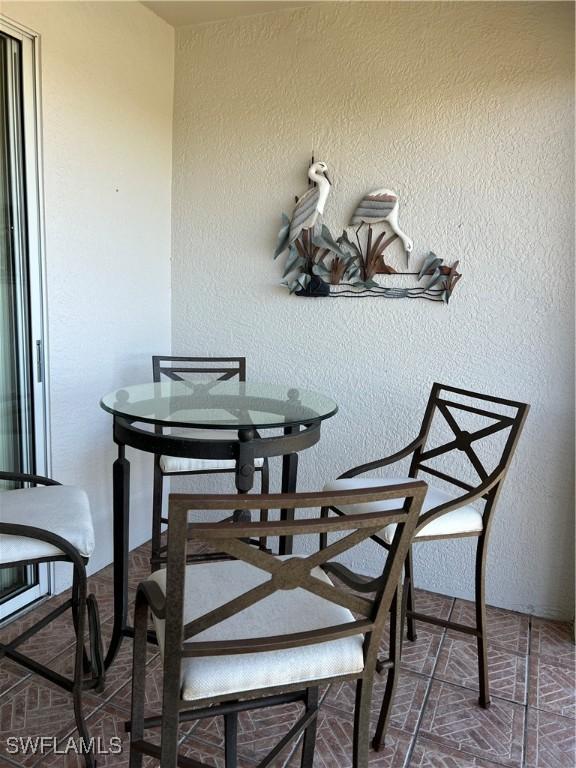 dining area with a textured wall and brick floor