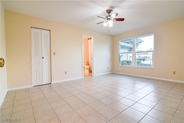 spare room featuring light tile patterned flooring, baseboards, and ceiling fan