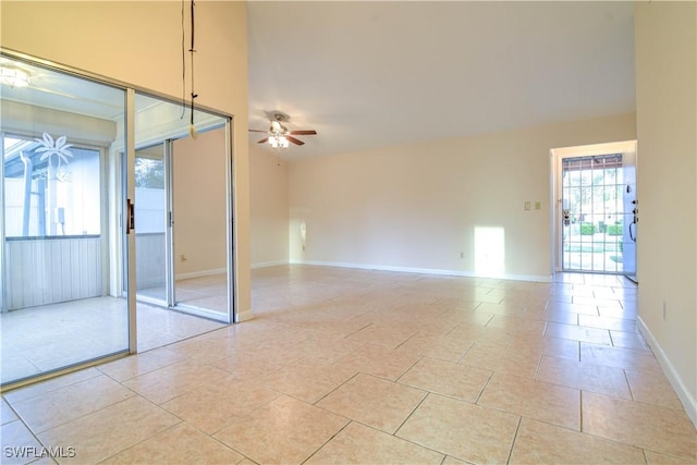 spare room with baseboards, ceiling fan, and light tile patterned flooring