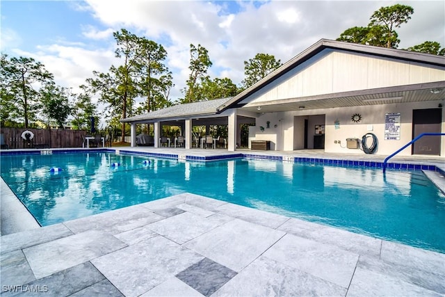 pool with fence and a patio area