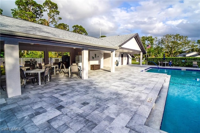 community pool with a patio and fence